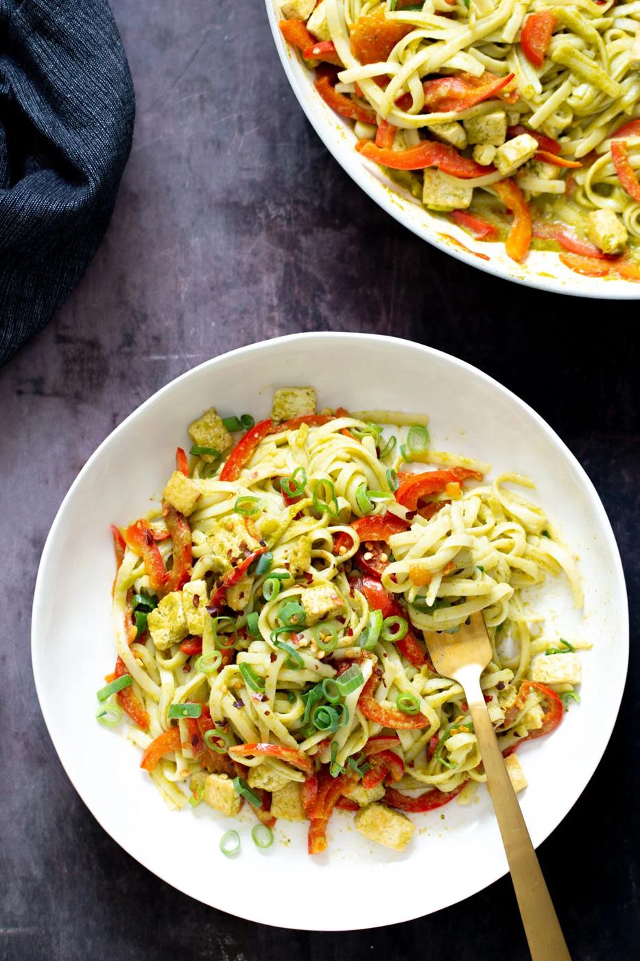 two bowls of thai green curry noodles with pan-fried tofu cubes