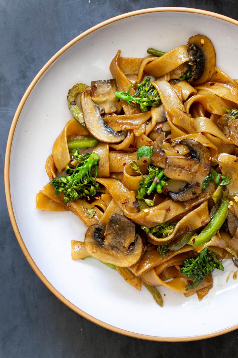 a plate with Thai style skillet stir fry noodles with mushrooms and broccoli