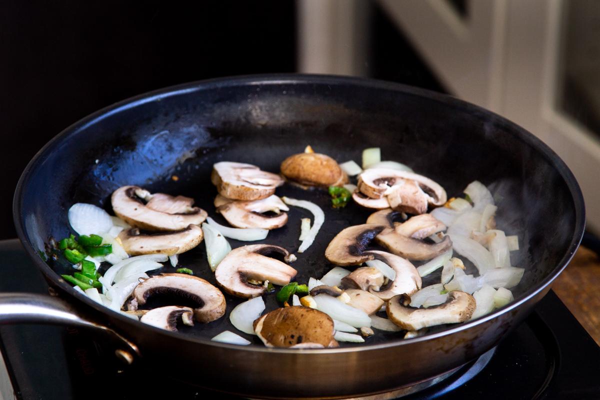 sliced mushrooms, chili and garlic in a black skillet