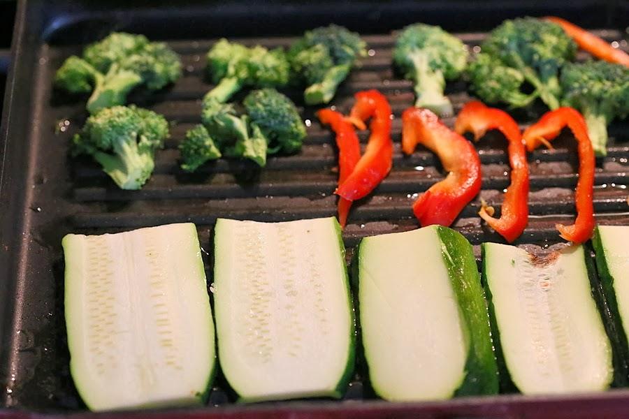 sliced zucchini, red bell peppers and broccoli florets in a grill pan