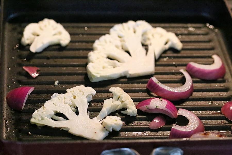 cauliflower and onion slices roasting in a grill pan