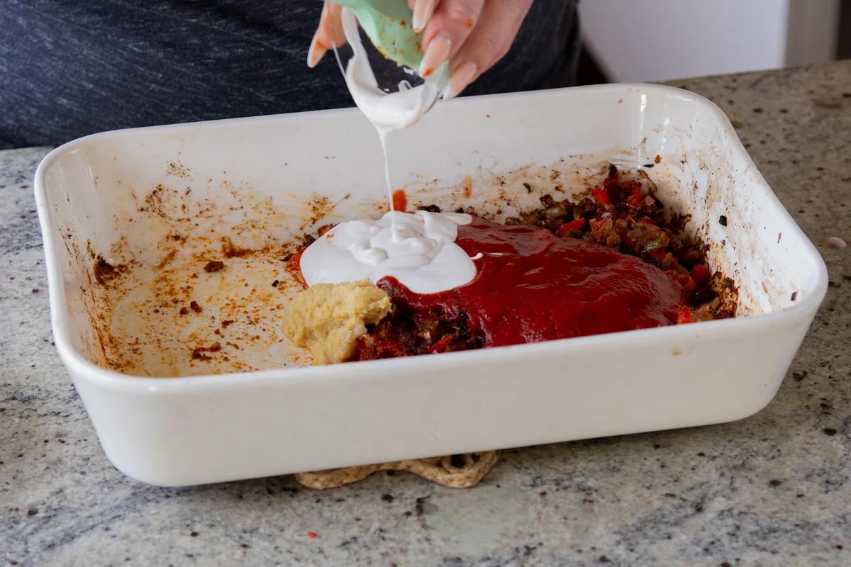 adding tomato puree and non-dairy yogurt to the pan