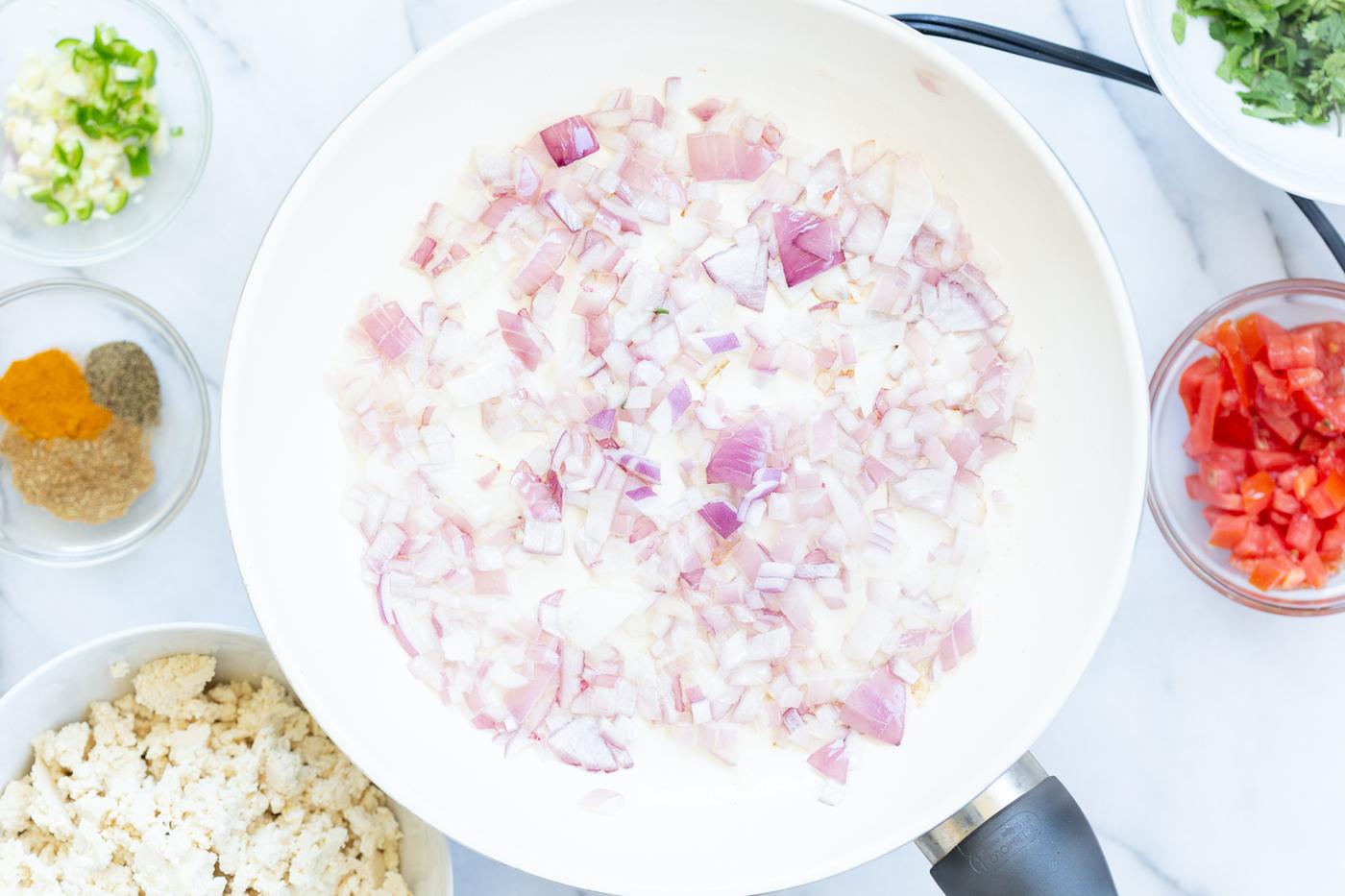 Chopped Onion in a white skillet for our Vegan Tofu Bhurji