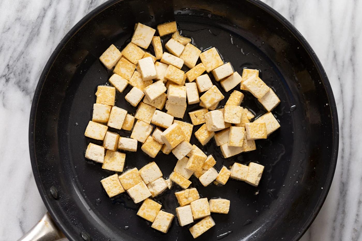 overhead shot of a skillet with oan-fried tofu cubes