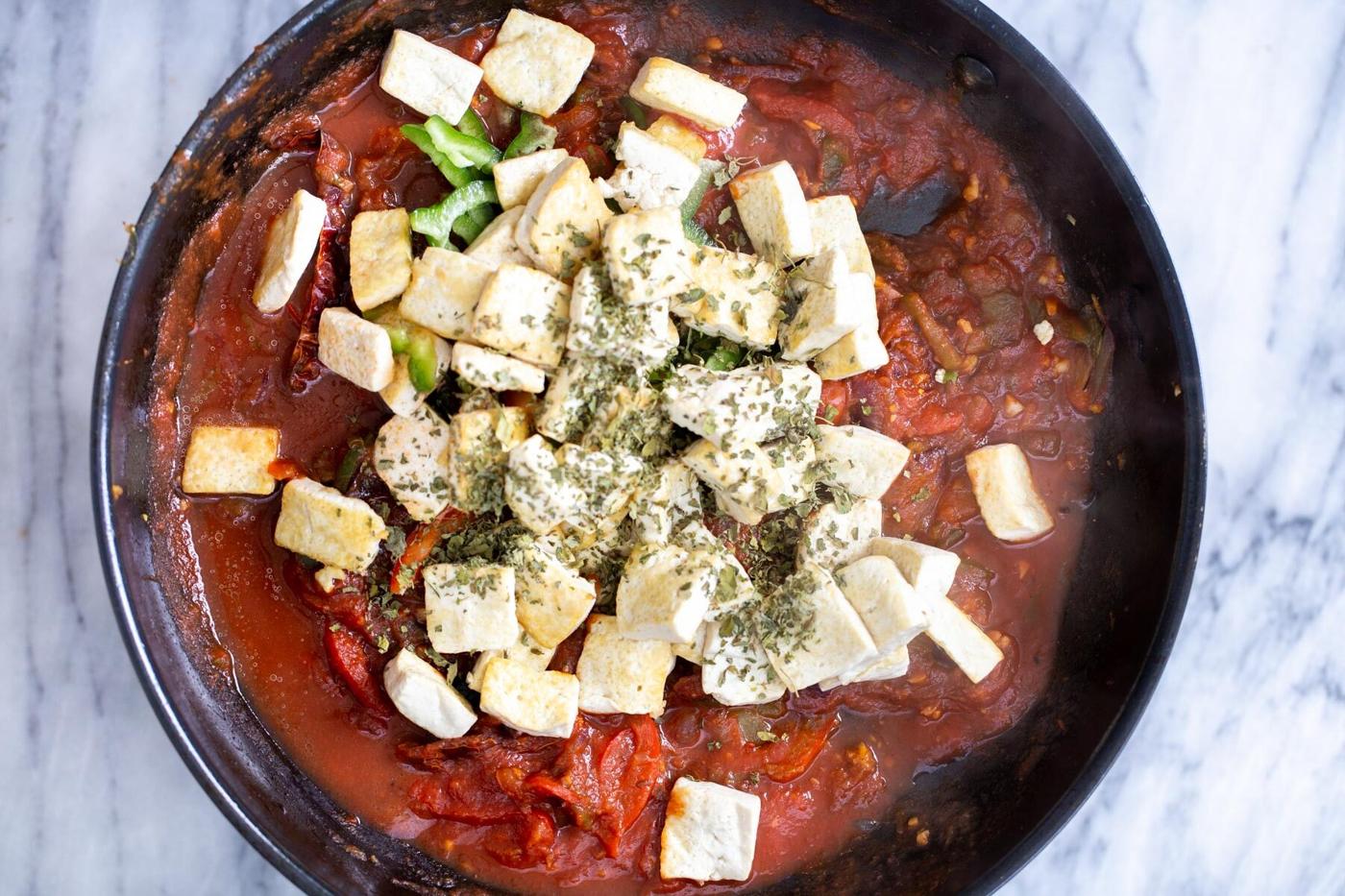 black skillet with tomato gravy and golden fried tofu cubes