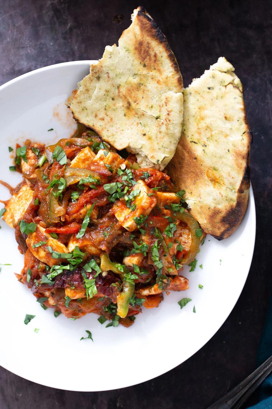 a serving of vegan tofu curry served wit ha side of naan bread