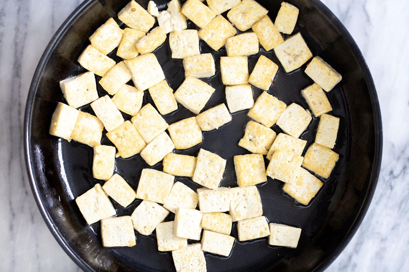 seared golden tofu in a frying pan