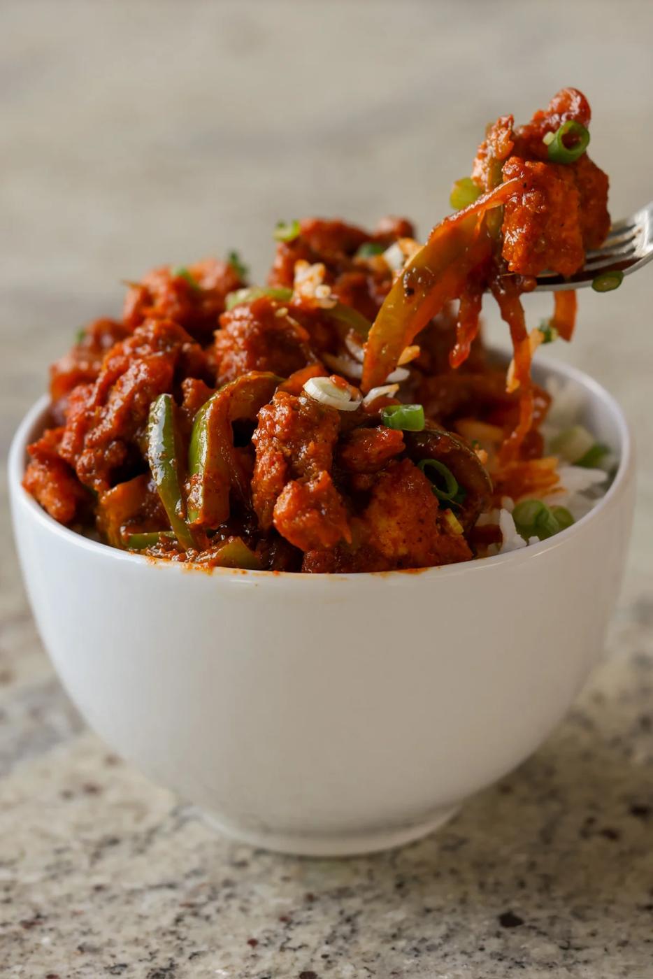 fork lifting a bite out of a bowl of tofu kondattam
