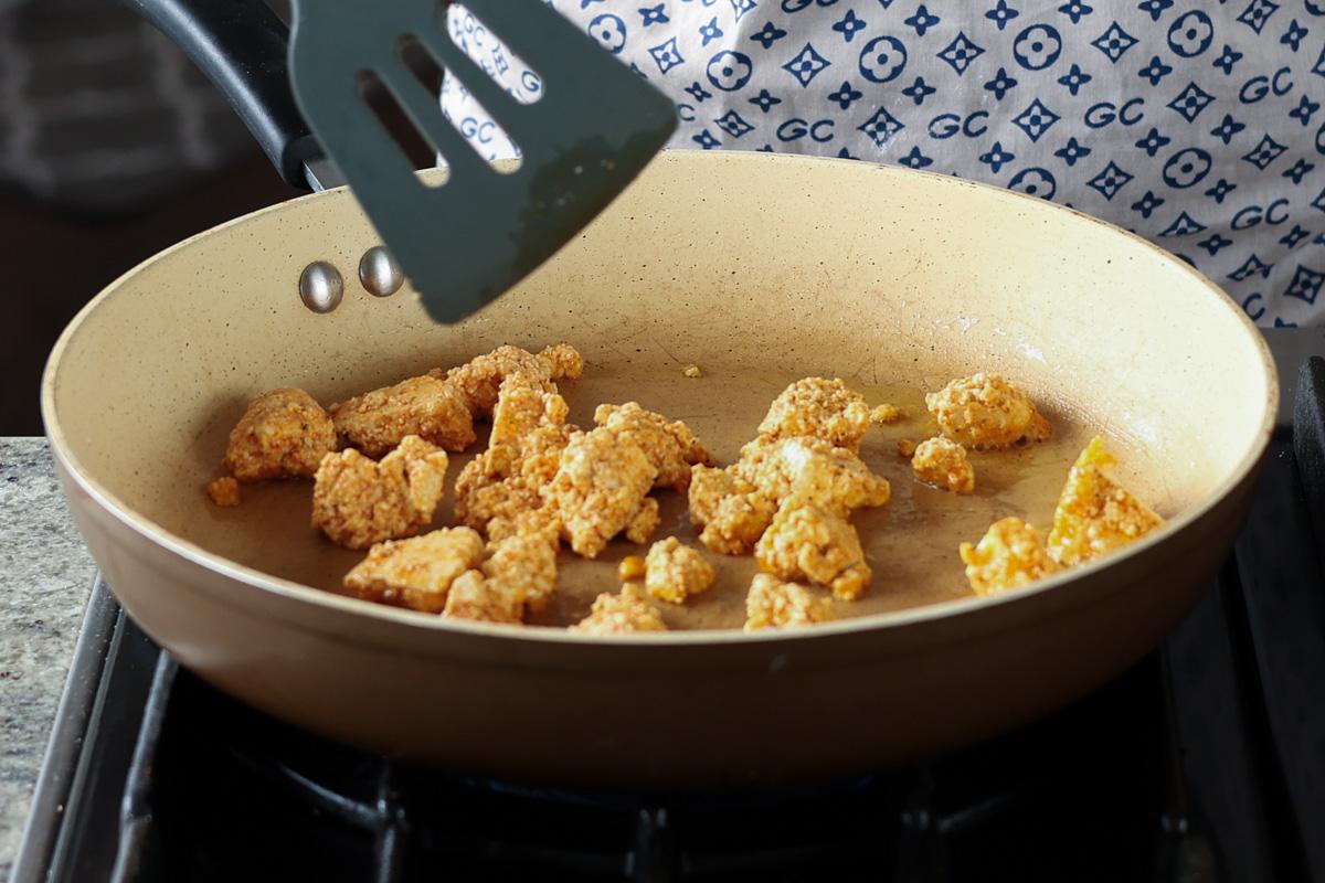 adding battered tofu to the frying pan