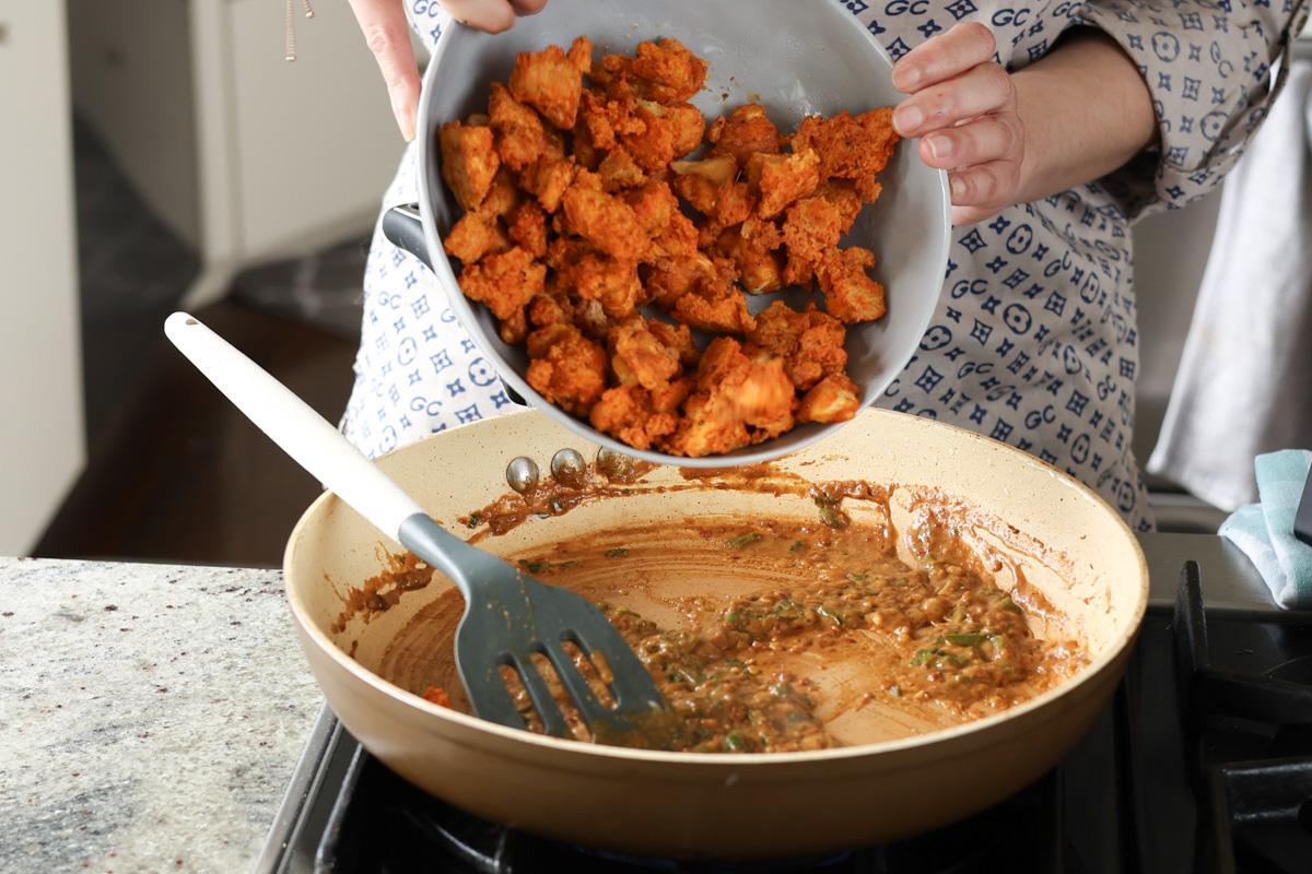 adding the tofu to the sauce