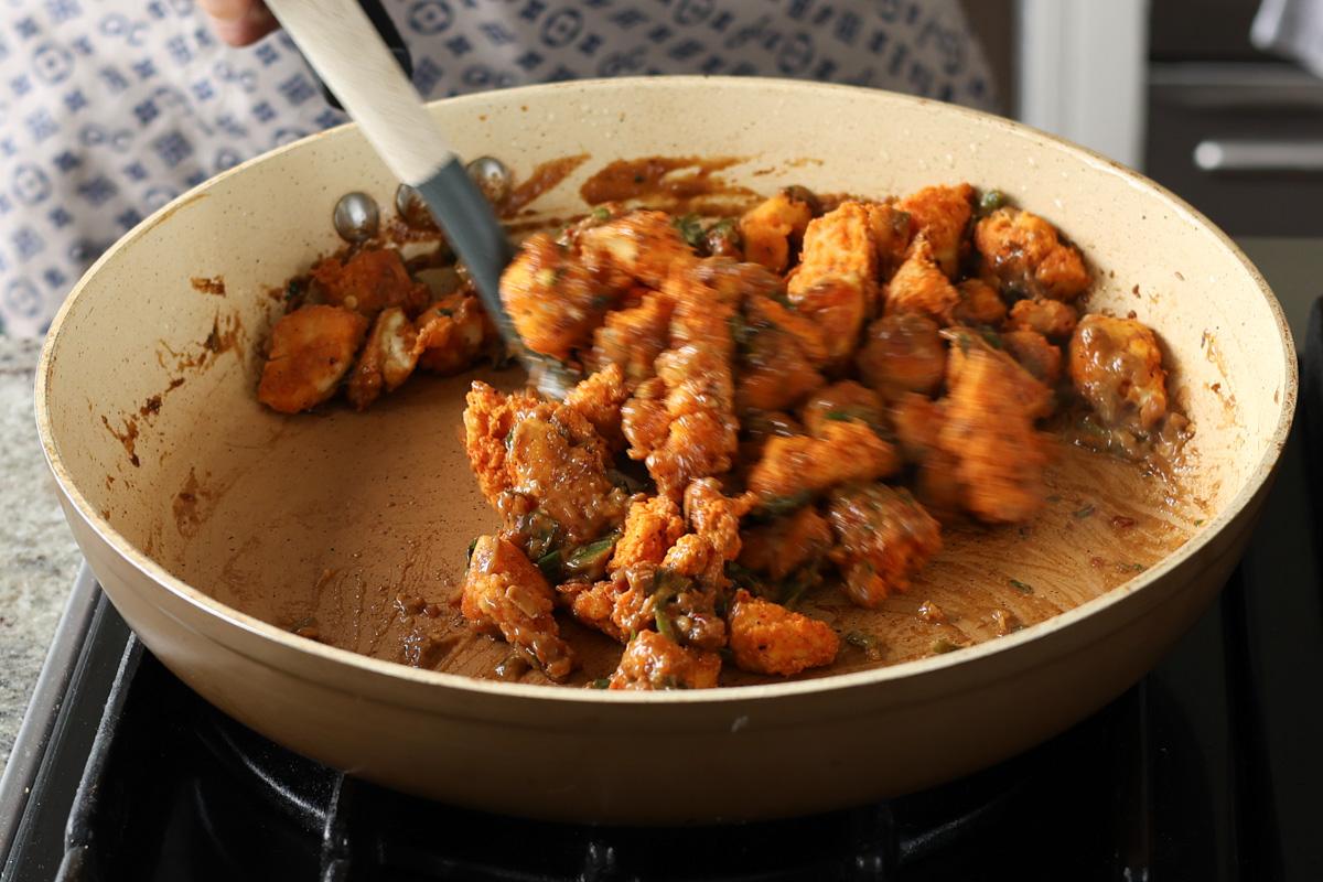 tossing the tofu in the sauce