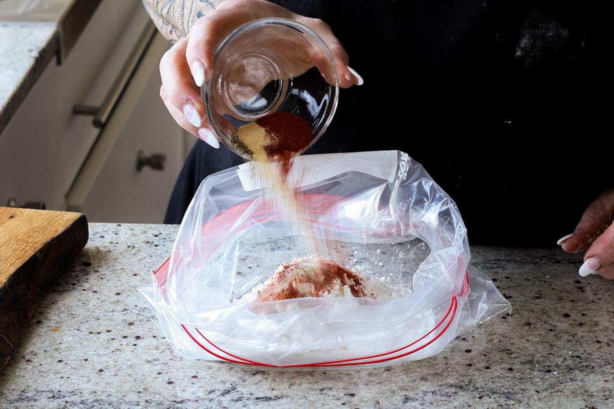 adding spices to a zip top bag