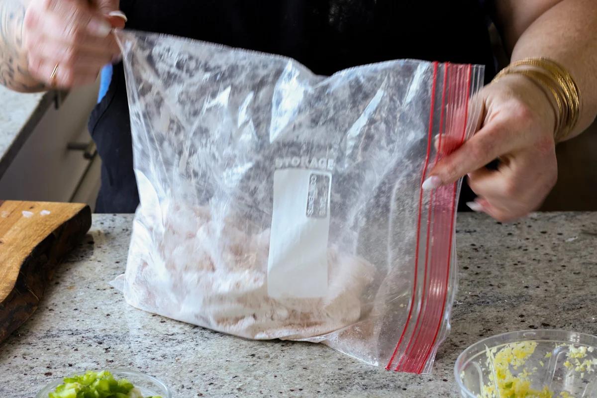 shaking the bag to coat the tofu in the rice flour mixture