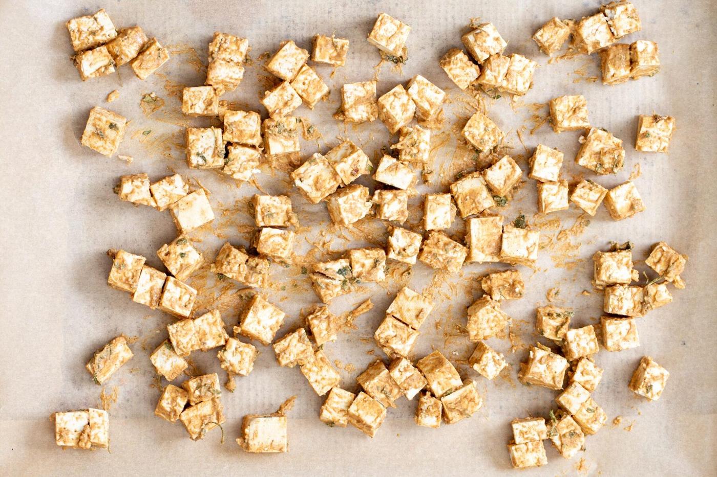 marinated tofu cubes on a lined baking sheet