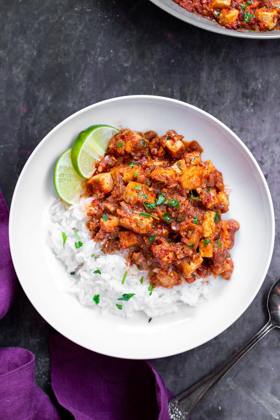 tofu vindaloo on a plate served with rice and lime slices