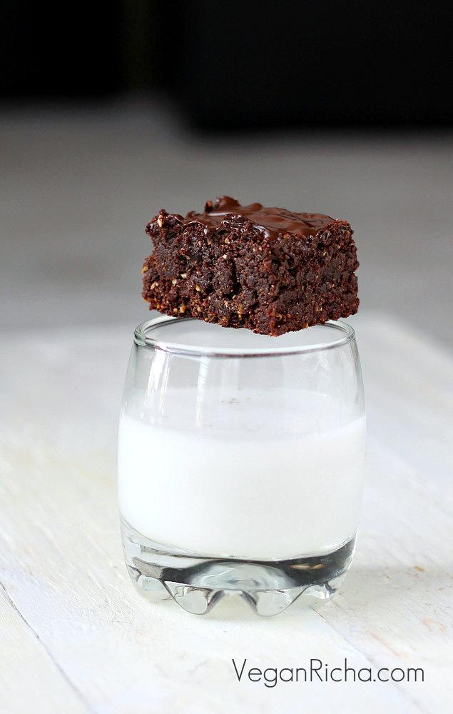a vegan triple chocolate salted caramel brownie placed on a milk glass