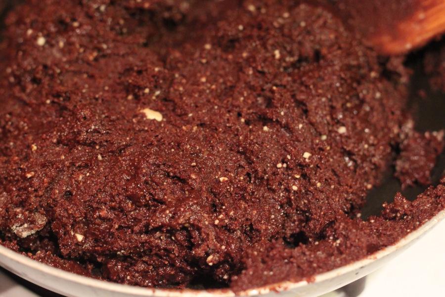 vegan triple chocolate brownie batter being pressed into a baking pan