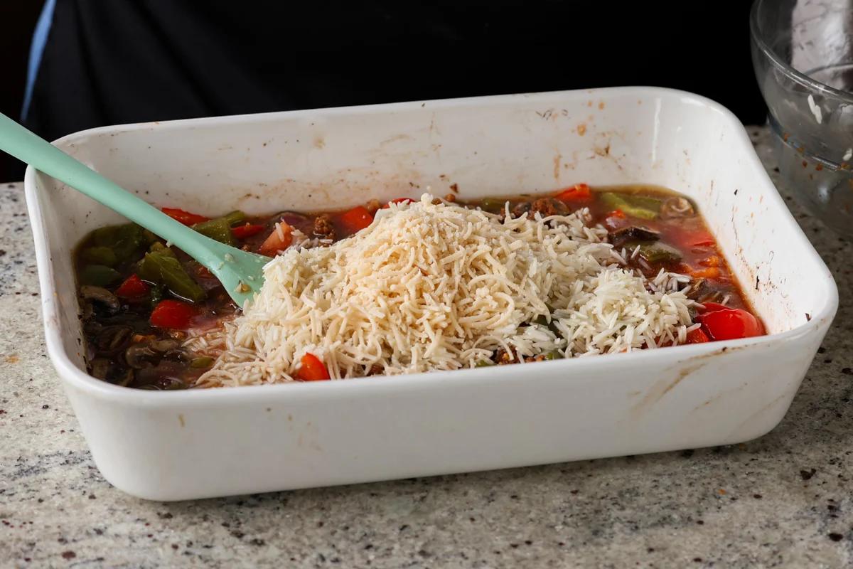adding rice and vegan mozzarella to the pan