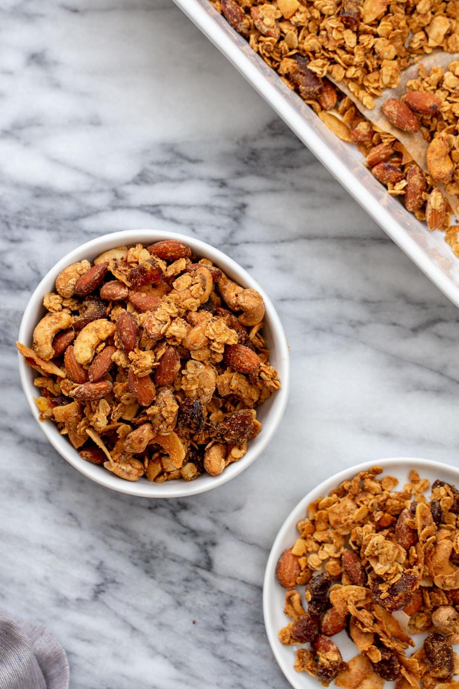 two small bowls of vegan almond coconut granola on a marble countertop