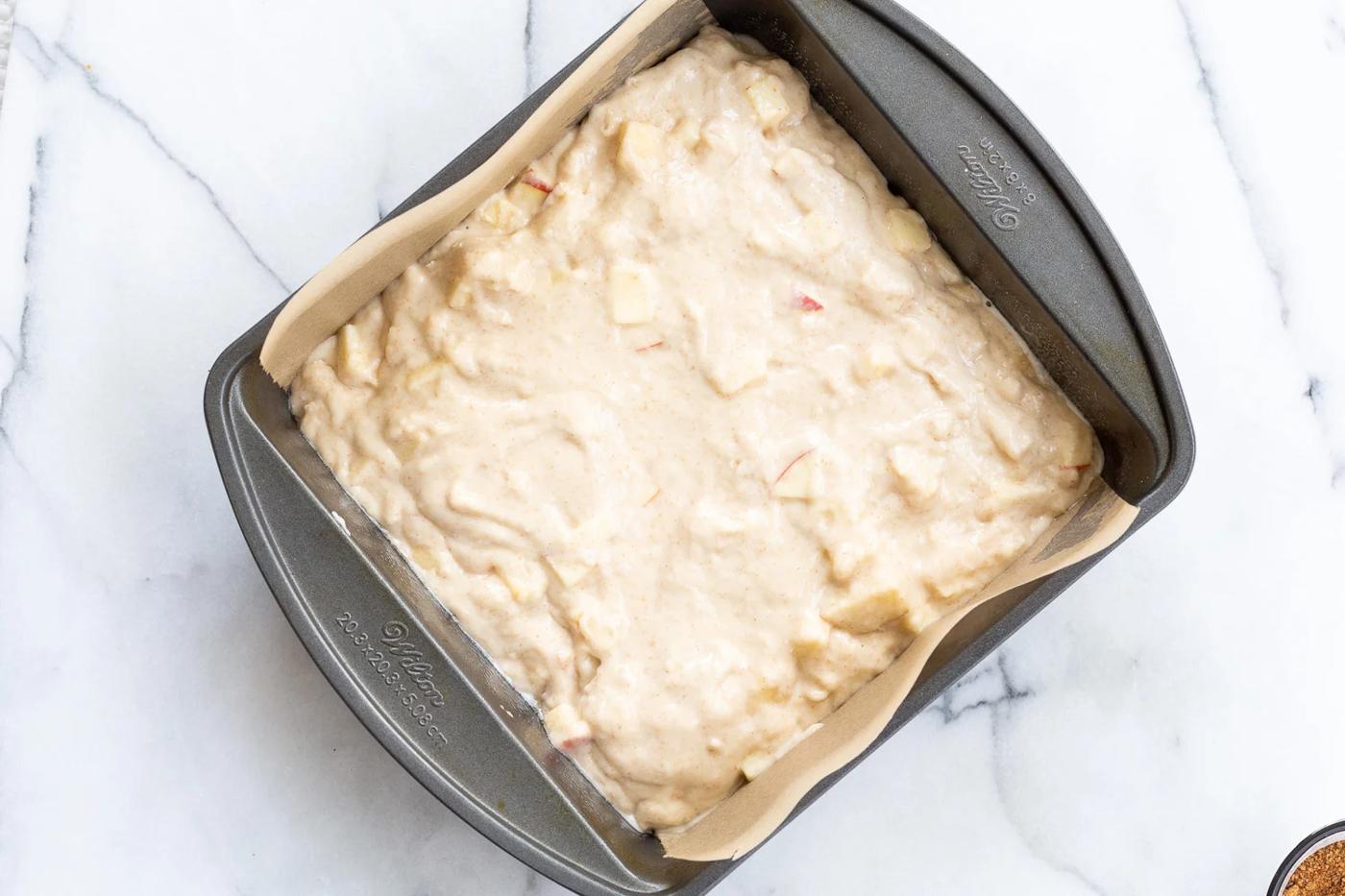 Vegan Apple Cake batter in parchment lined pan