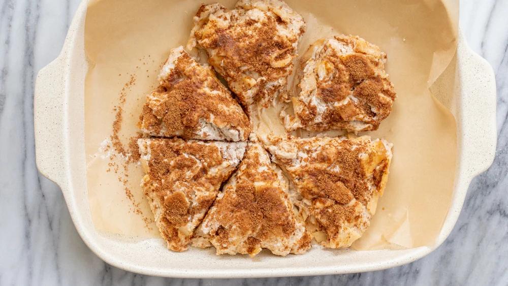 Sliced Scone Dough for our Vegan Apple Cinnamon Scones in a parchment lined white baking dish