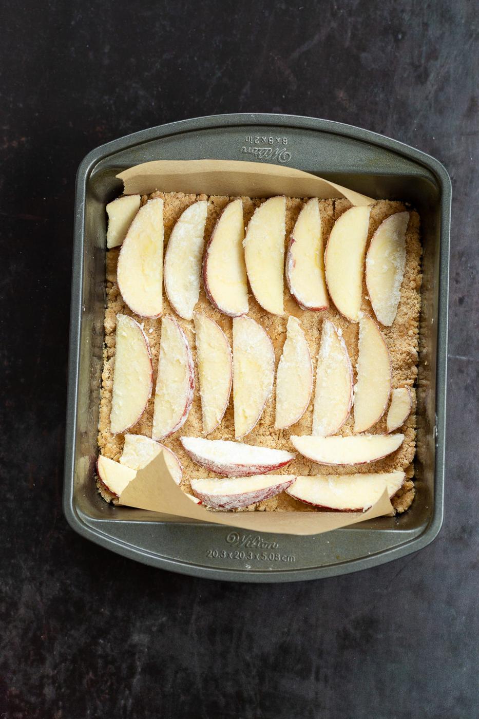 Apple over Crust for our Vegan Apple Custard Squares in a lined brownie pan