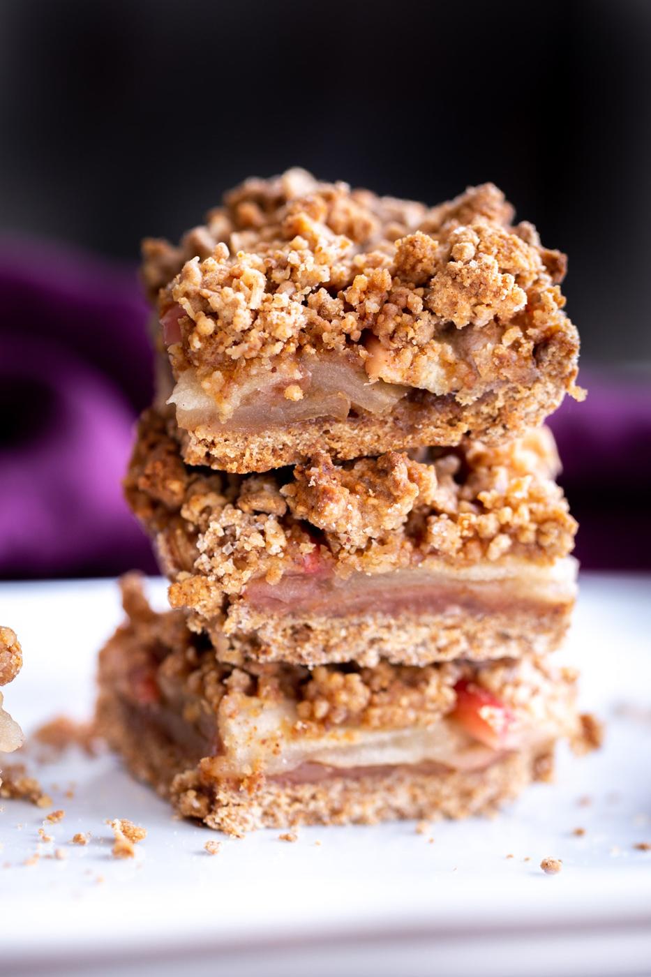stacked vegan apple pie bars against a black background