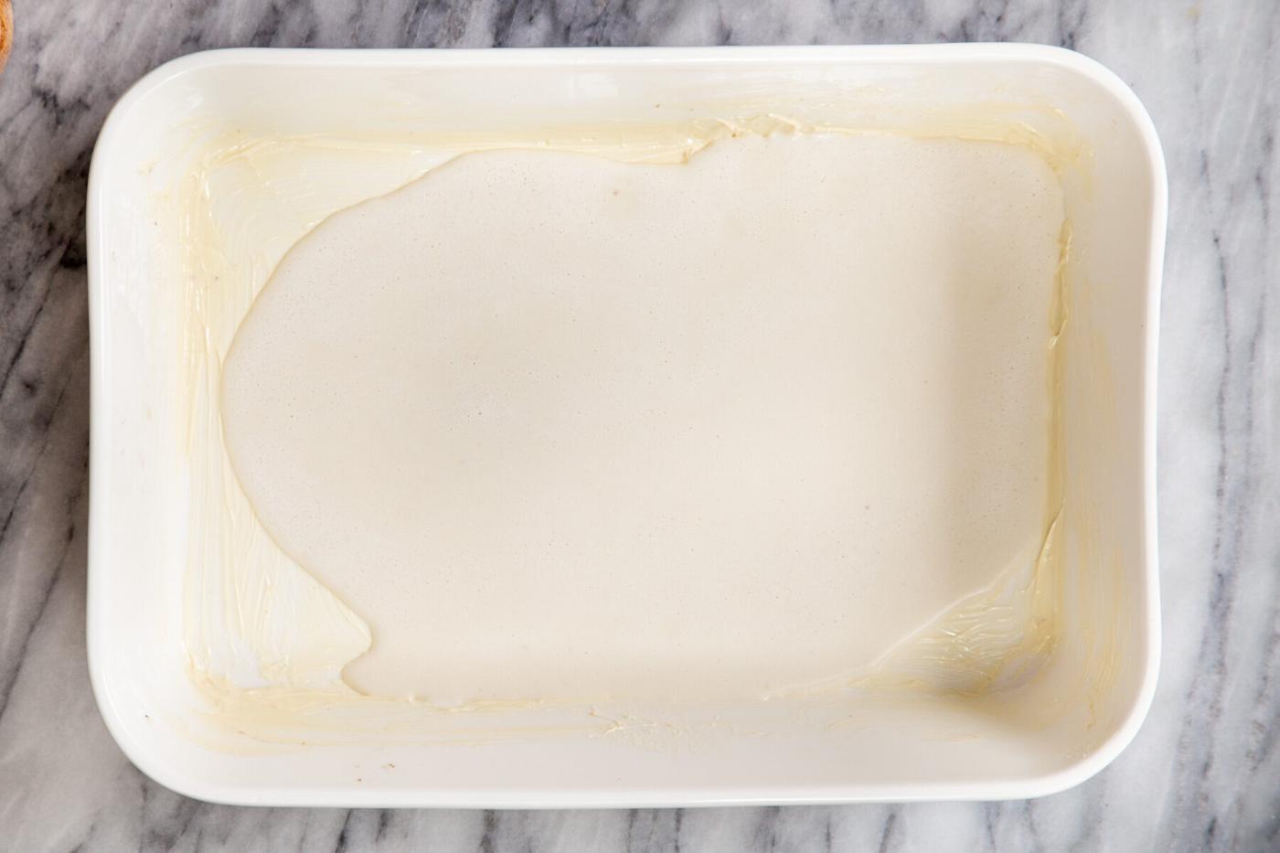 vegan cashew custard being poured into a casserole dish to make baked French toast