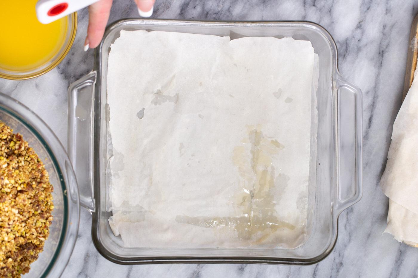 a casserole dish being lined with phyllo pastry