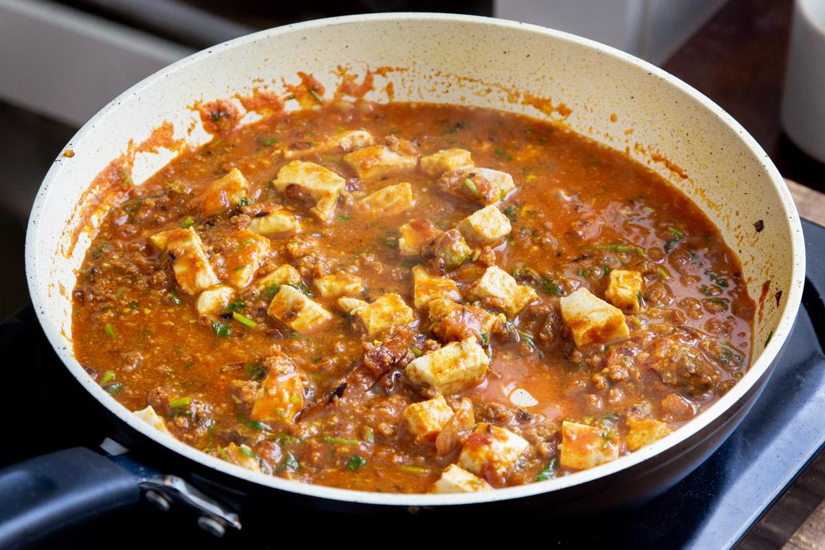 vegan balti chicken with tofu and vegan crumbles simmering in a gravy
