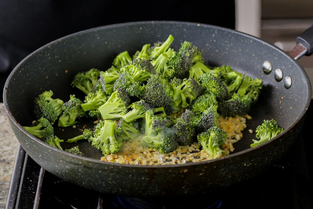 adding broccoli to the pan