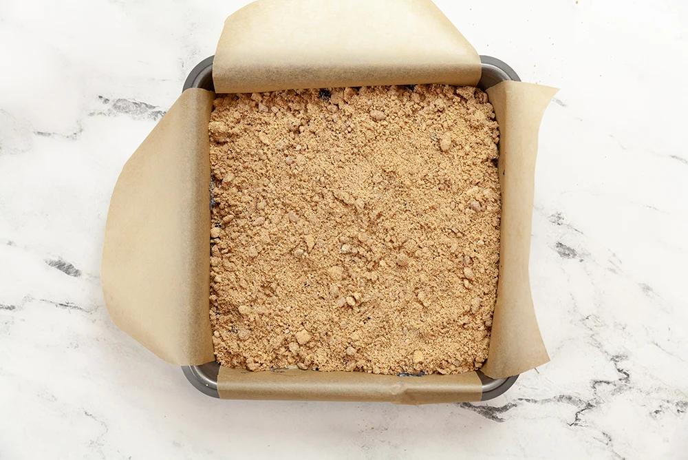 Berry Buckle Batter with streusel in a parchment lined baking dish