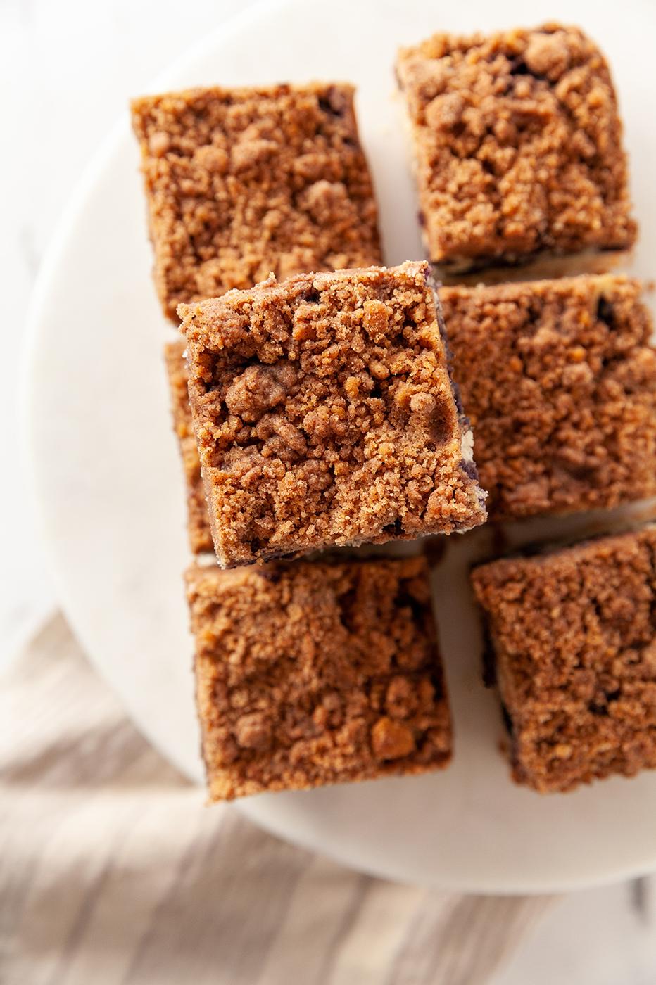 Vegan Blueberry Buckle slices on a white cake stand