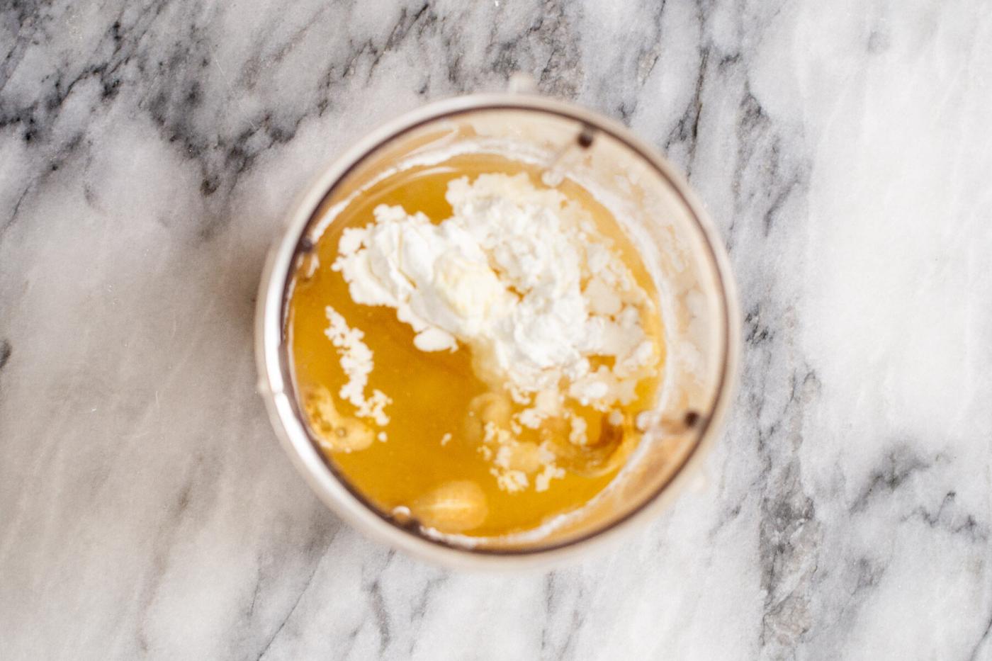 cornstarch being added to vegan custard ingredients in a blender