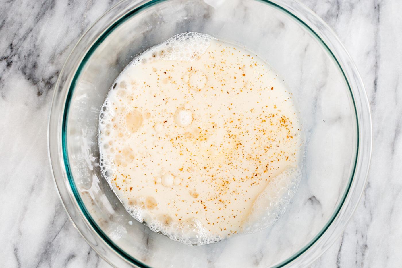 liquid ingredients for vegan boston cream pie cake in a glass bowl