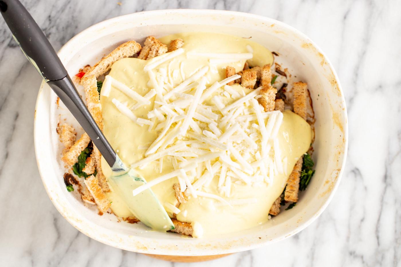 vegan cheese shreds being sprinkled on top of vegan breakfast casserole