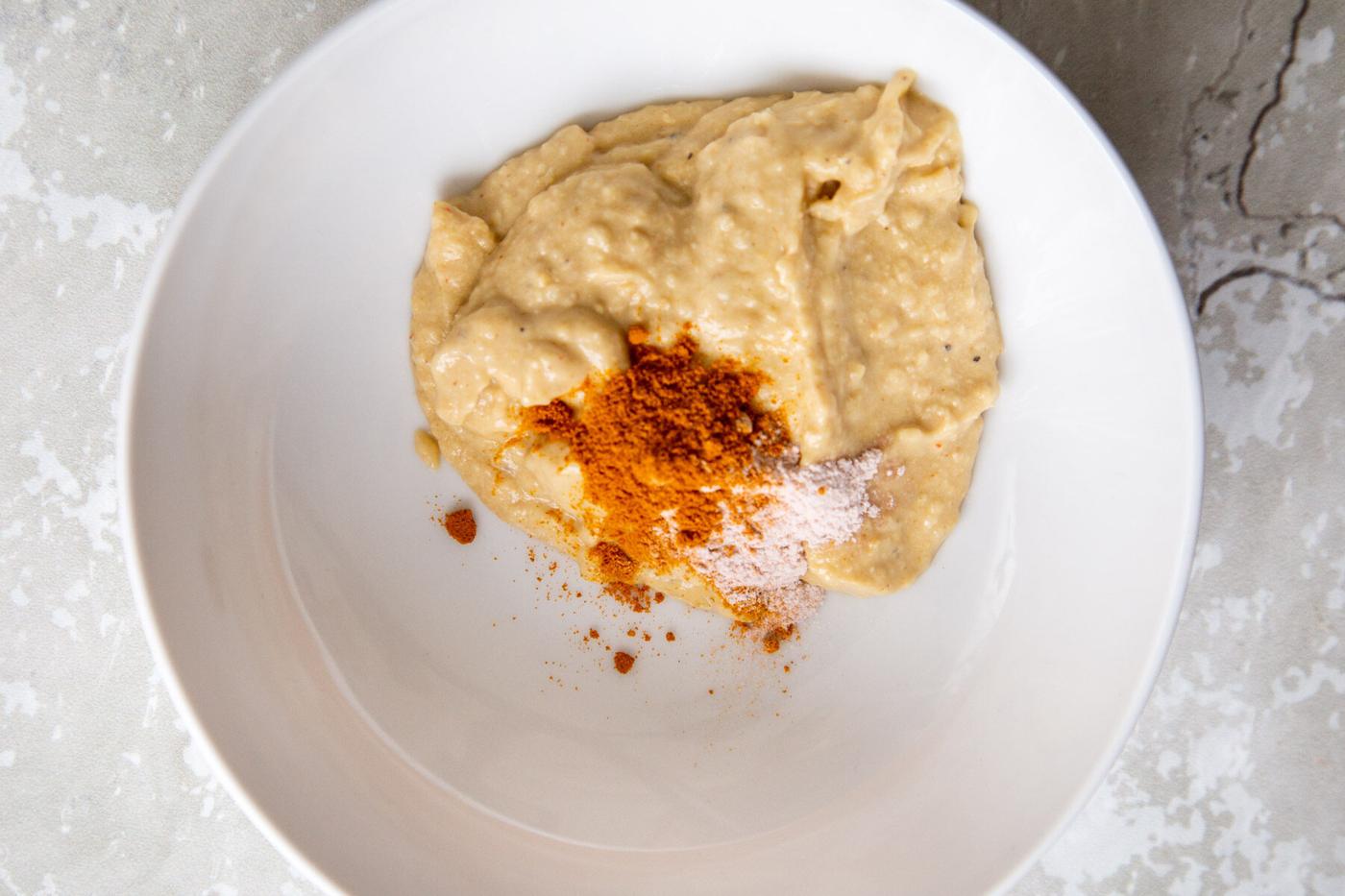 hummus with turmeric and sulfur salt in a white bowl