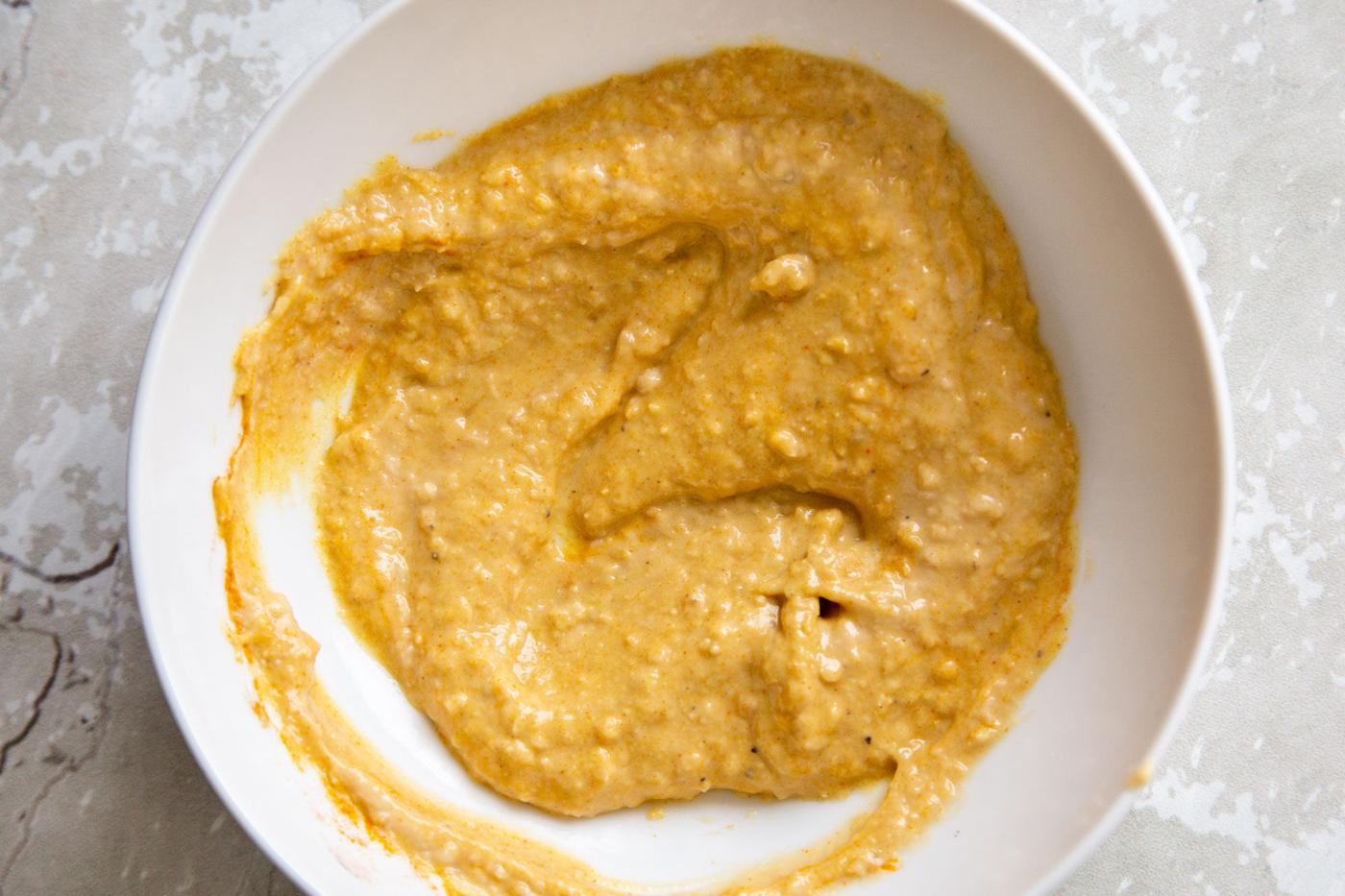 vegan eggy hummus with turmeric in a white bowl
