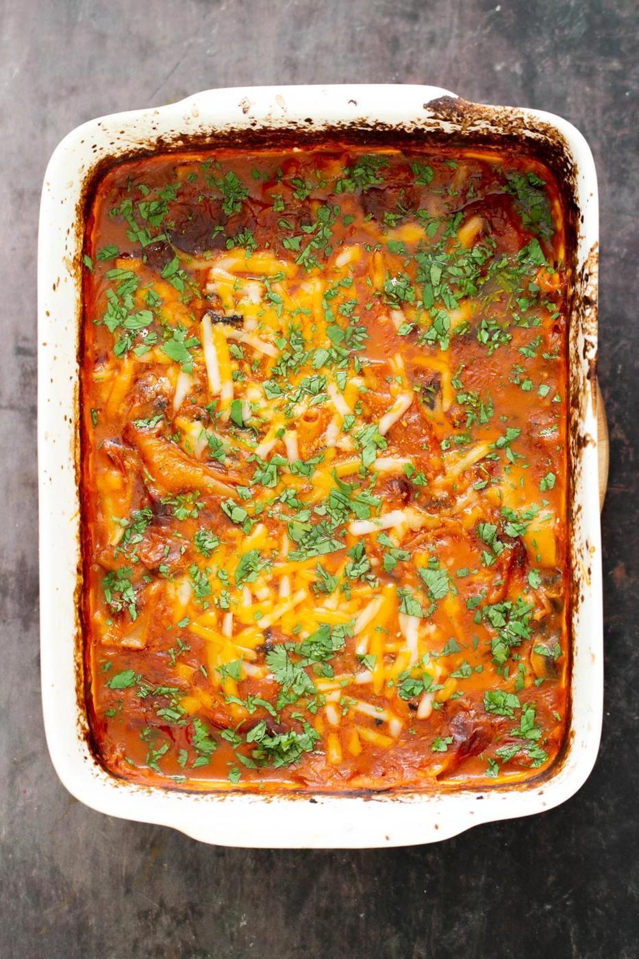 a casserole dish with vegan butter chicken lasagna bake sprinkled with chopped cilantro