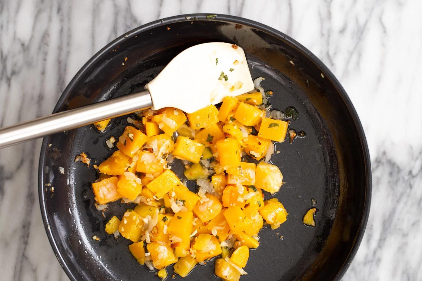 butternut squash being sauteed in a skillet