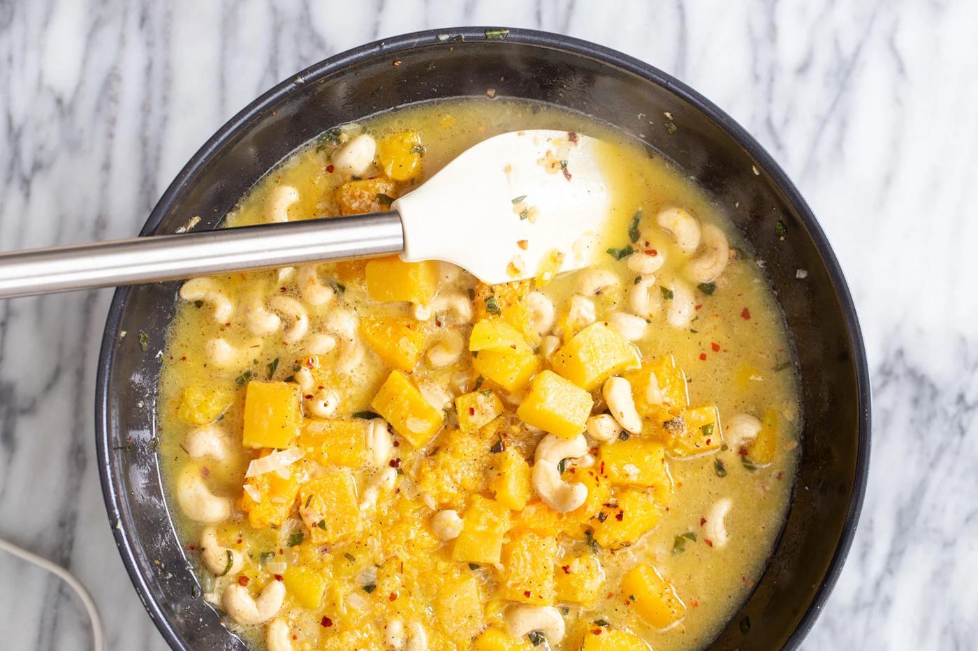butternut squash pasta sauce being cooked in a back skillet