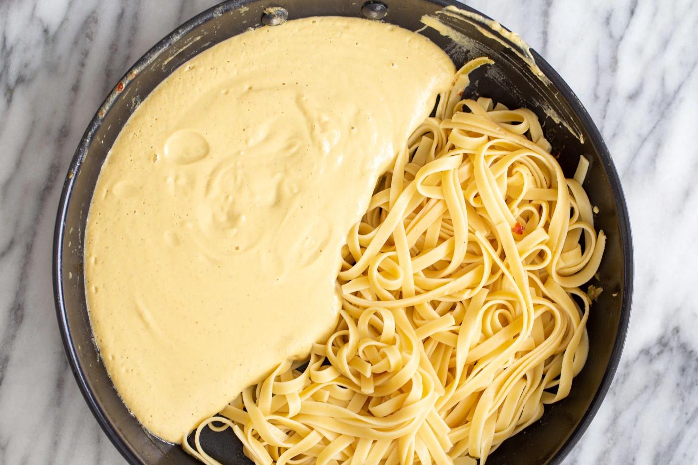 overhead shot of a skillet with linguine with creamy butternut squash carbonara sauce