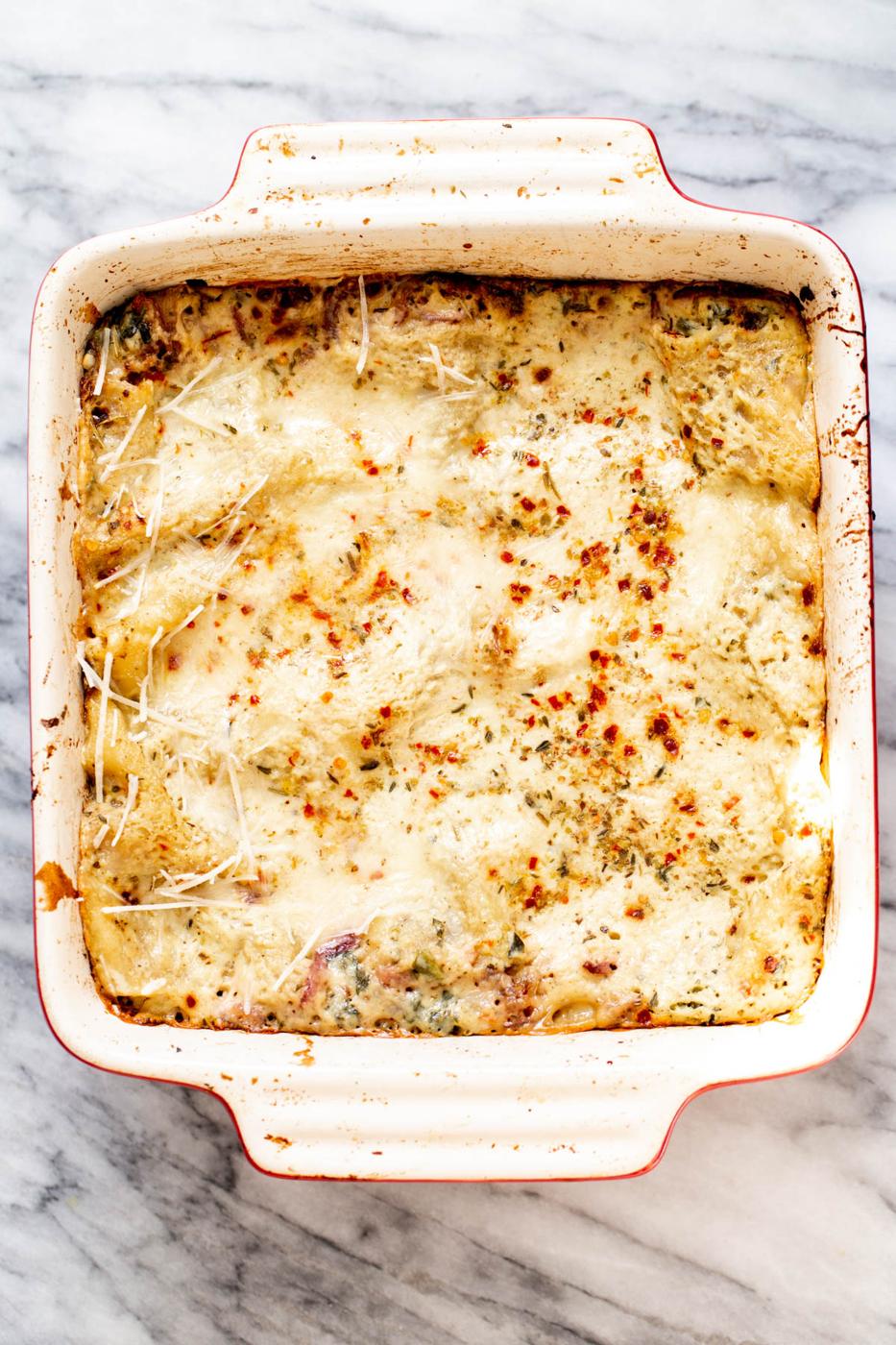a casserole dish with vegan spinach, onion & butternut squash lasagna