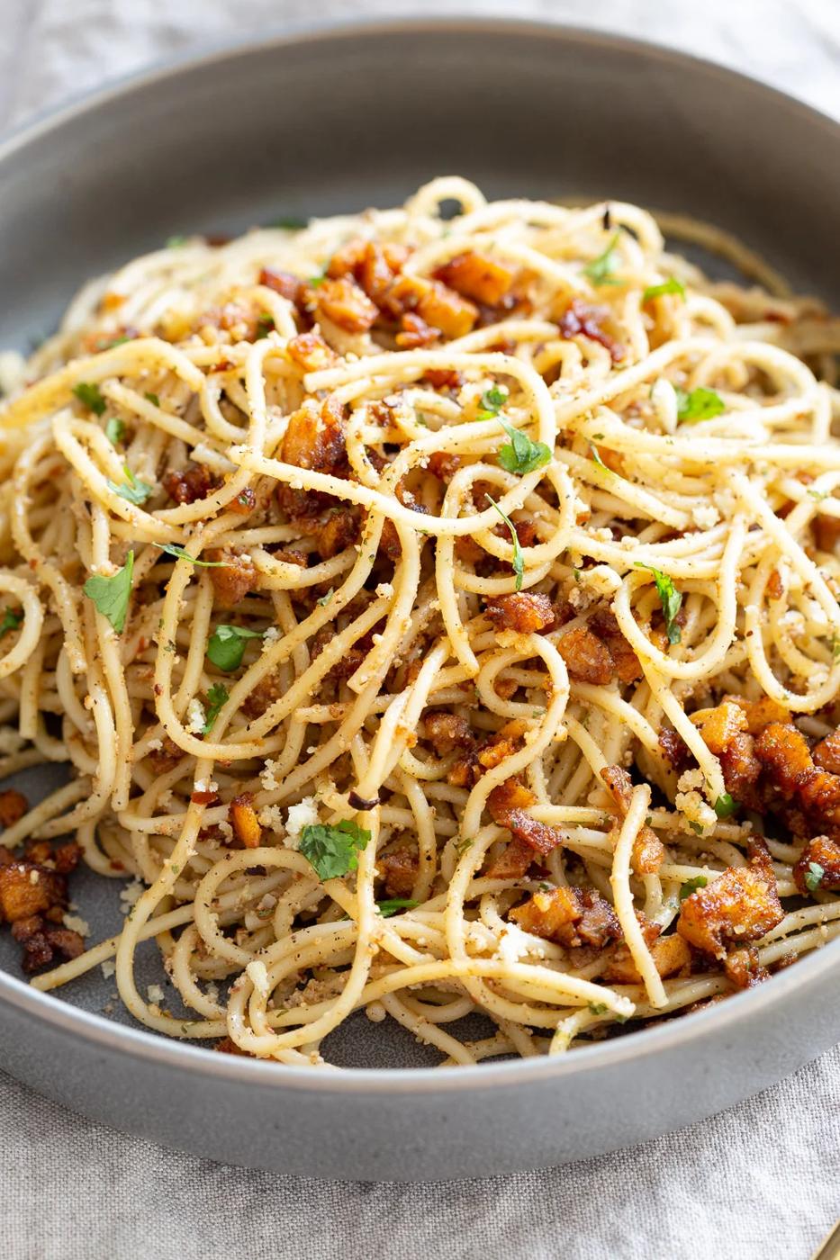 Vegan Cacio e Pepe with Smoky Balsamic Roasted Chickpea tofu in a grey bowl