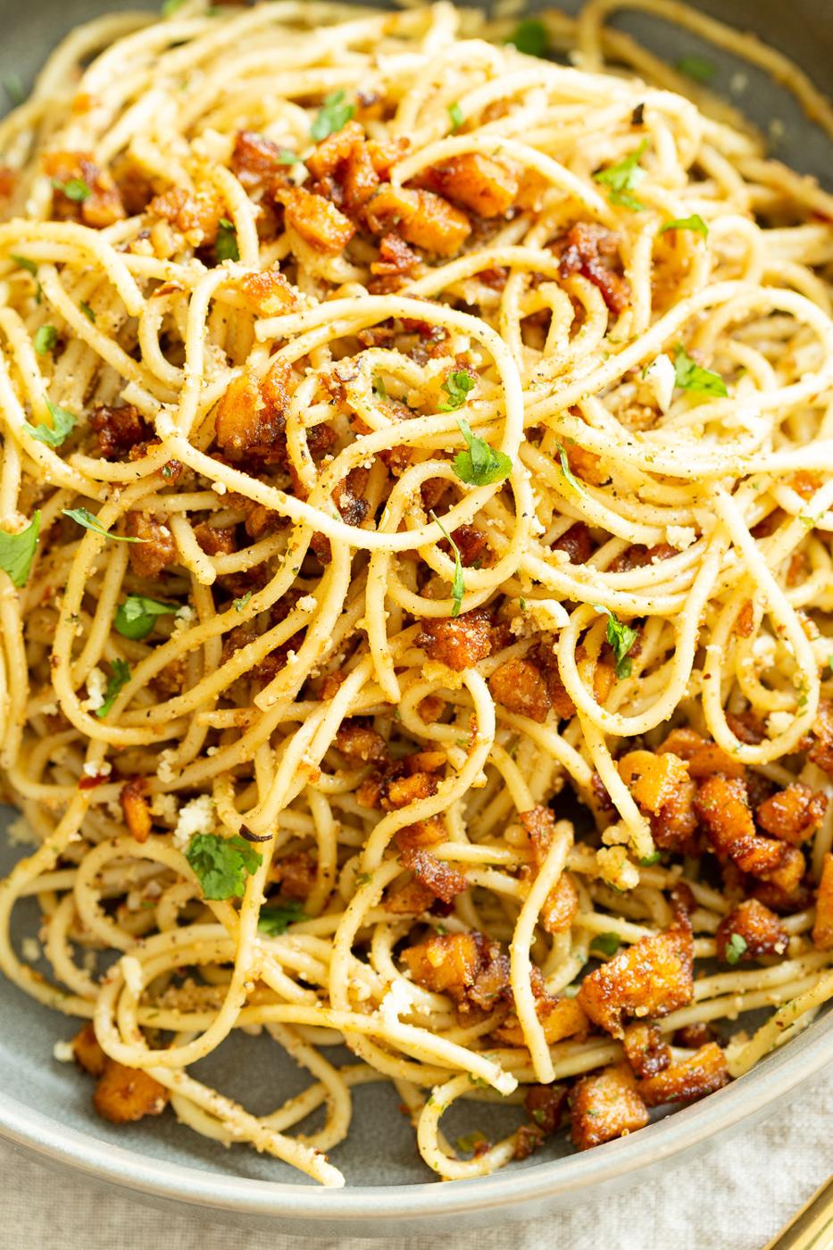 Vegan Cacio e Pepe with Smoky Balsamic Roasted Chickpea tofu in a grey bowl