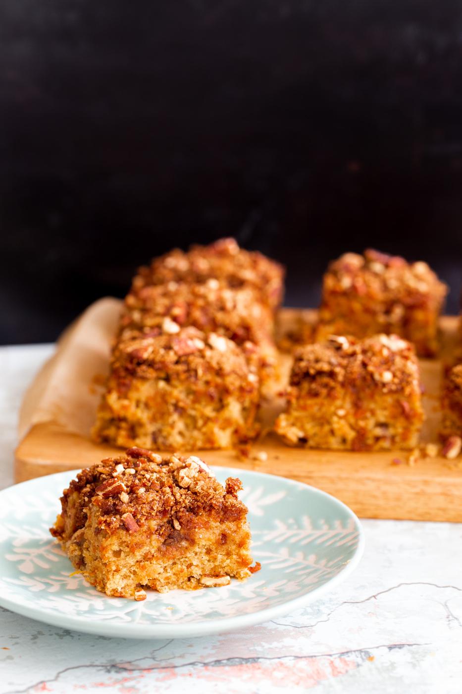 a square slice of vegan carrot cake bar on a white and blue cake plate