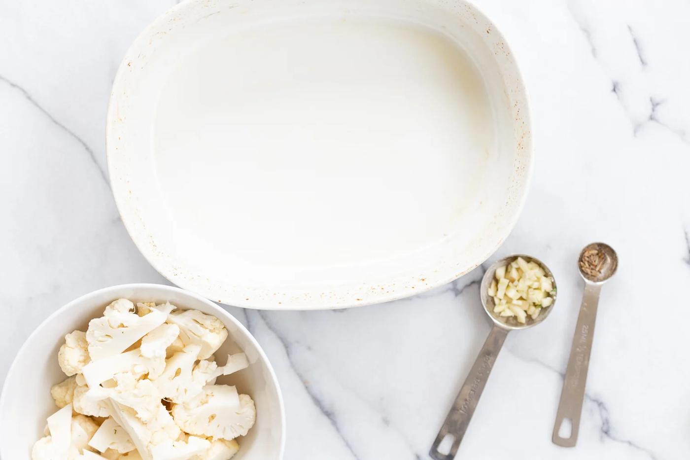 Cauliflower and garlic in a bowl for our Vegan Cauliflower Pea Curry Gobi Matar