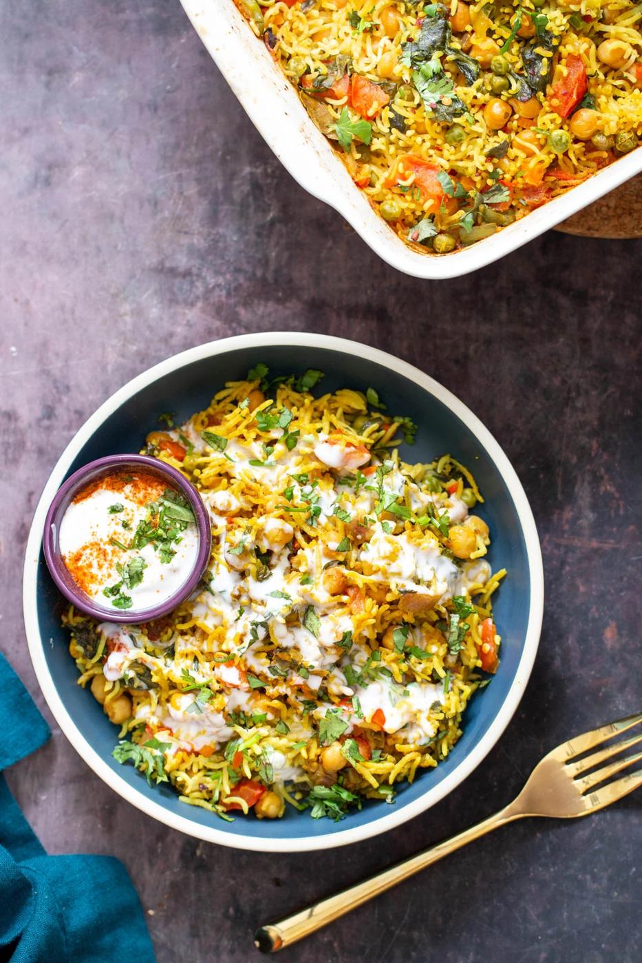 a bowl of vegan chana pulao chickpea rice casserole in a small bowl served with raita