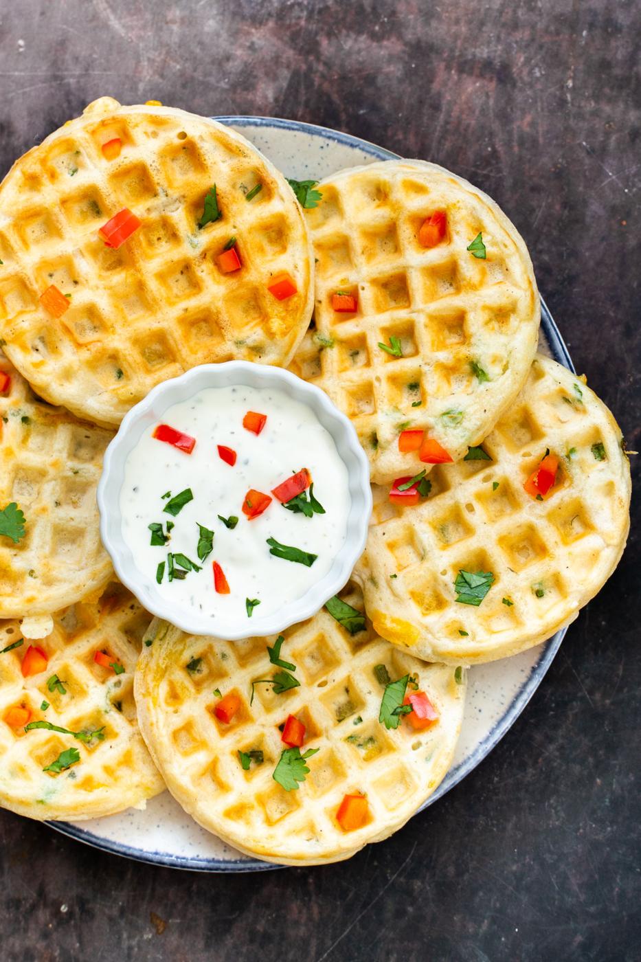 a plate of vegan jalapeno waffles with a small dish of vegan sour cream