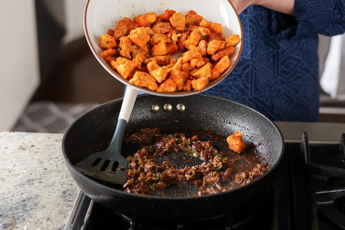 adding crispy tofu to the chicken 555 sauce